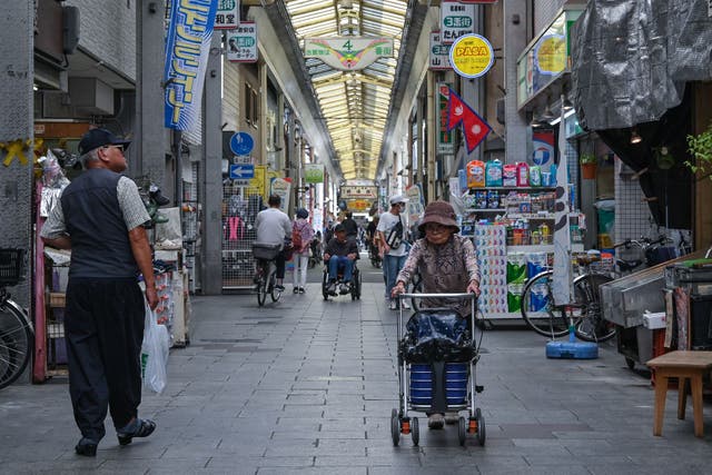 <p>This photo taken on 1 October 2025 shows shoppers walking through the Tsurumibashi ‘shotengai’, an old covered shopping street in the Nishinari ward of Osaka</p>