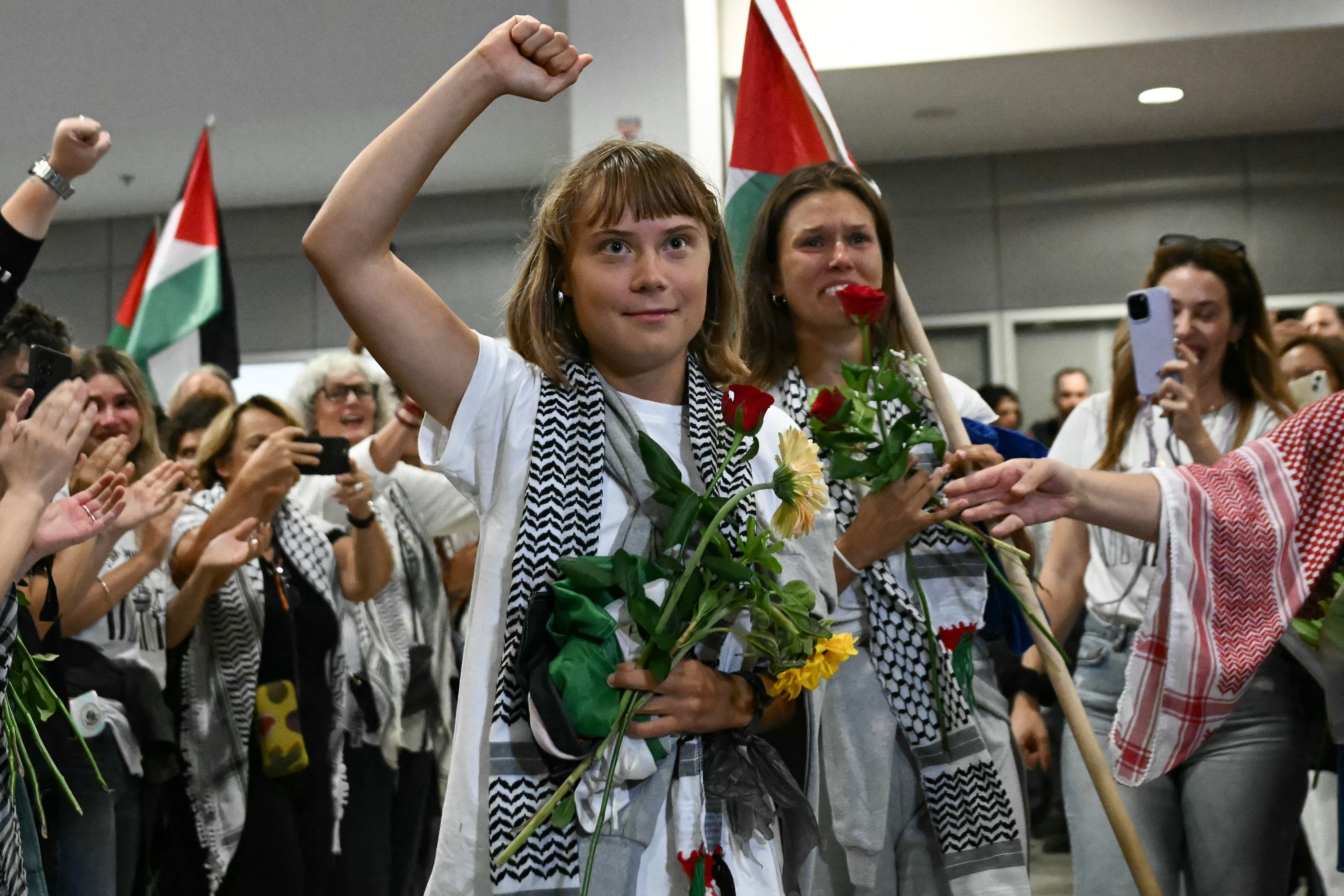 Thunberg raises her fist upon arrival in Athens alongside activists who were sailing aboard the Gaza aid flotilla