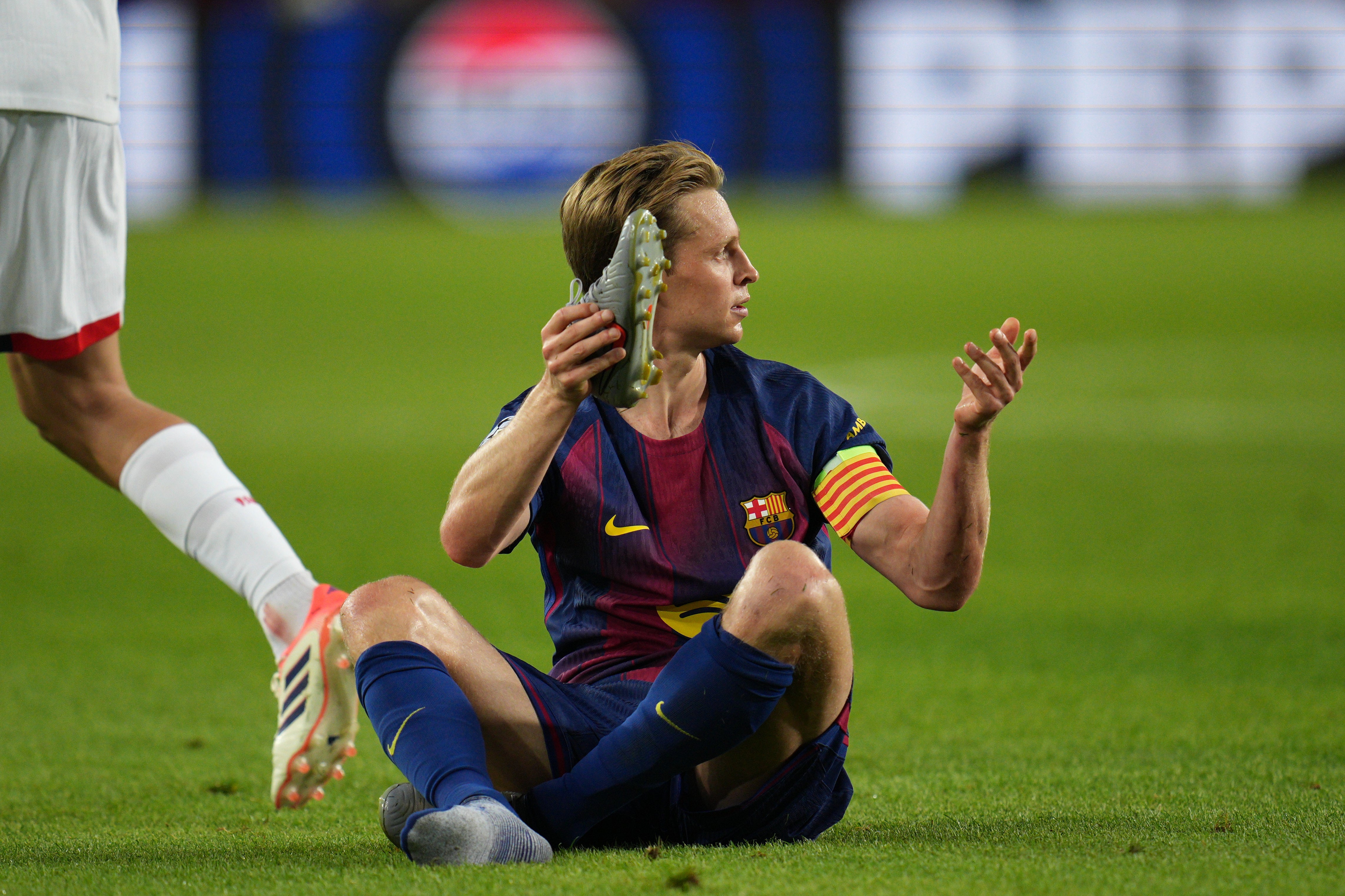 <p>Barcelona's Frenkie de Jong gestures holding his boot after being fouled during the Champions League opening phase soccer match between Barcelona and Paris Saint-Germain</p>