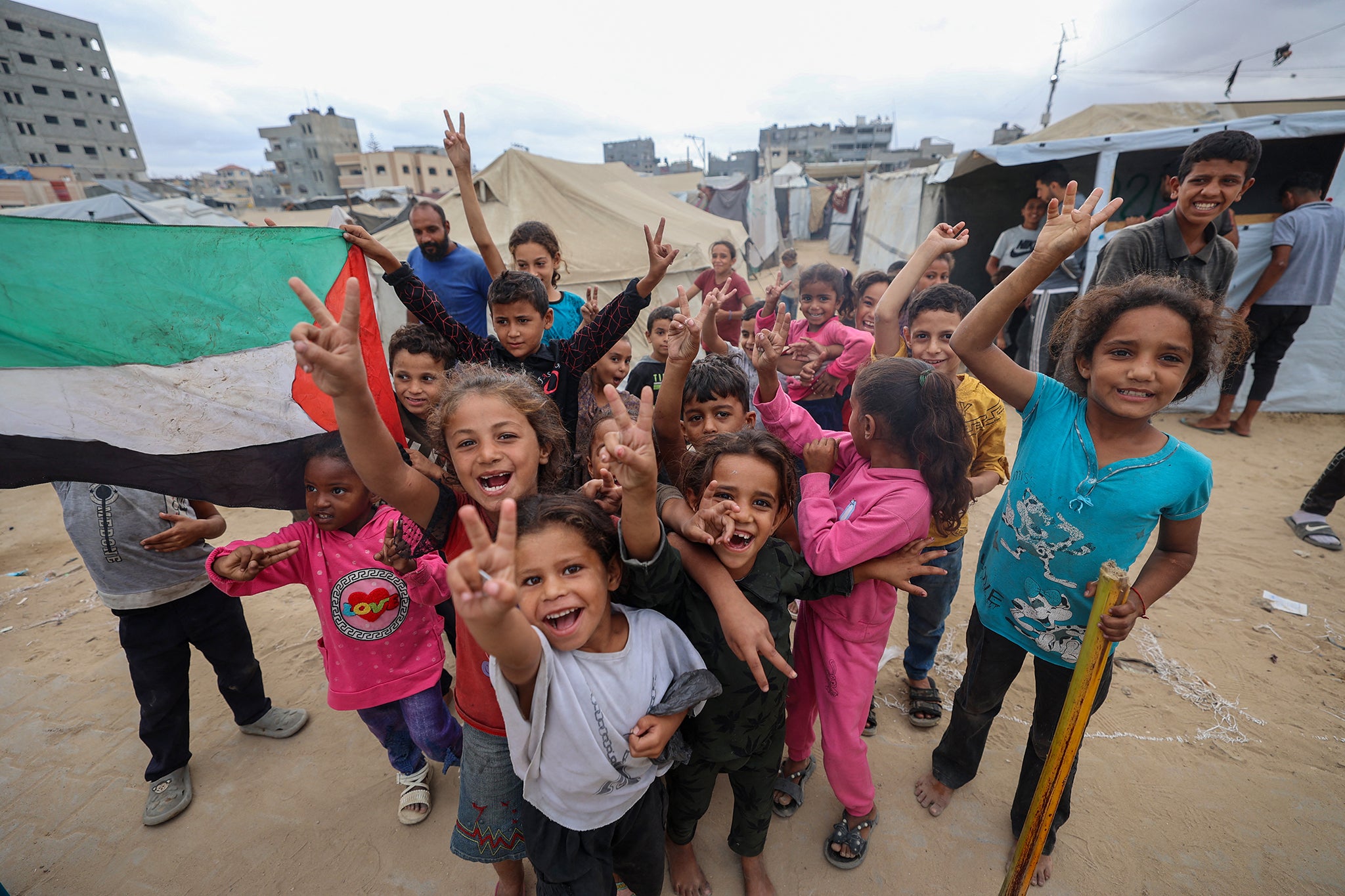 Children celebrate at a camp in Nuseirat, Gaza Strip, following news of a ceasefire deal