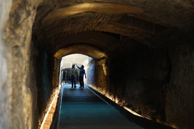 <p>Workers walk in the so-called 'Passage of Emperor Commodus', a newly restored tunnel ancient Roman emperors would use to enter the Colosseum unseen and protected, that will open to visitors at the end of the month</p>