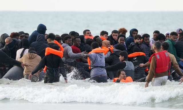 People scramble to board a small boat in Gravelines, France, on Thursday (Gareth Fuller/PA)