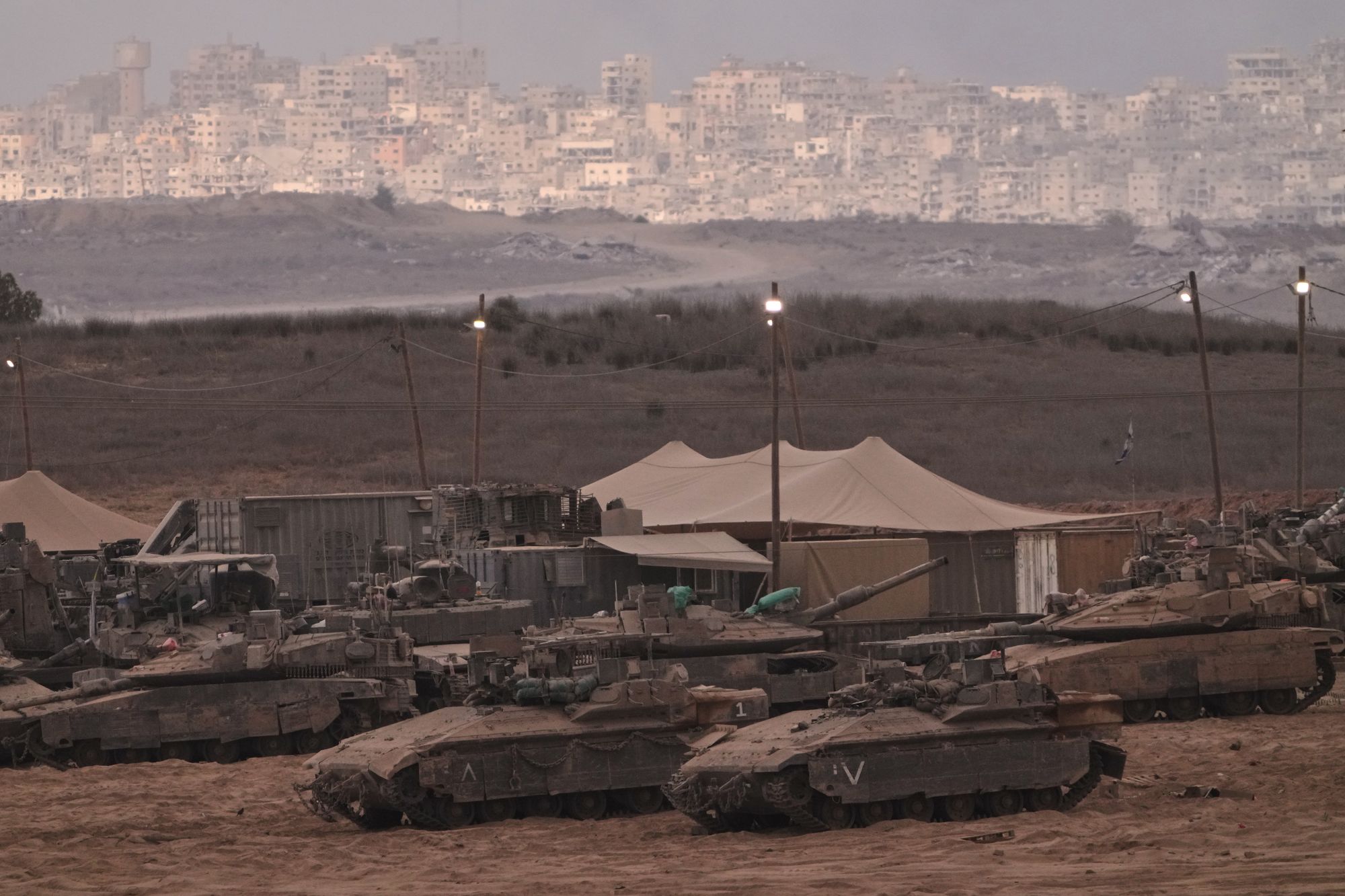 Tanques israelenses estão estacionados em um palco perto da fronteira entre Israel e Gaza, visto do sul de Israel