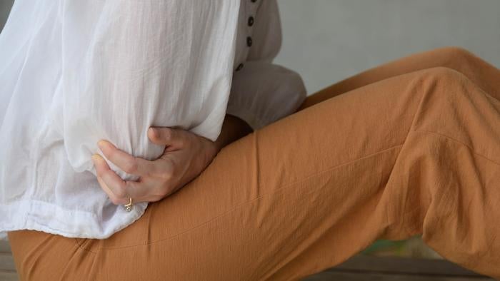 Woman showing sign of gut pain
