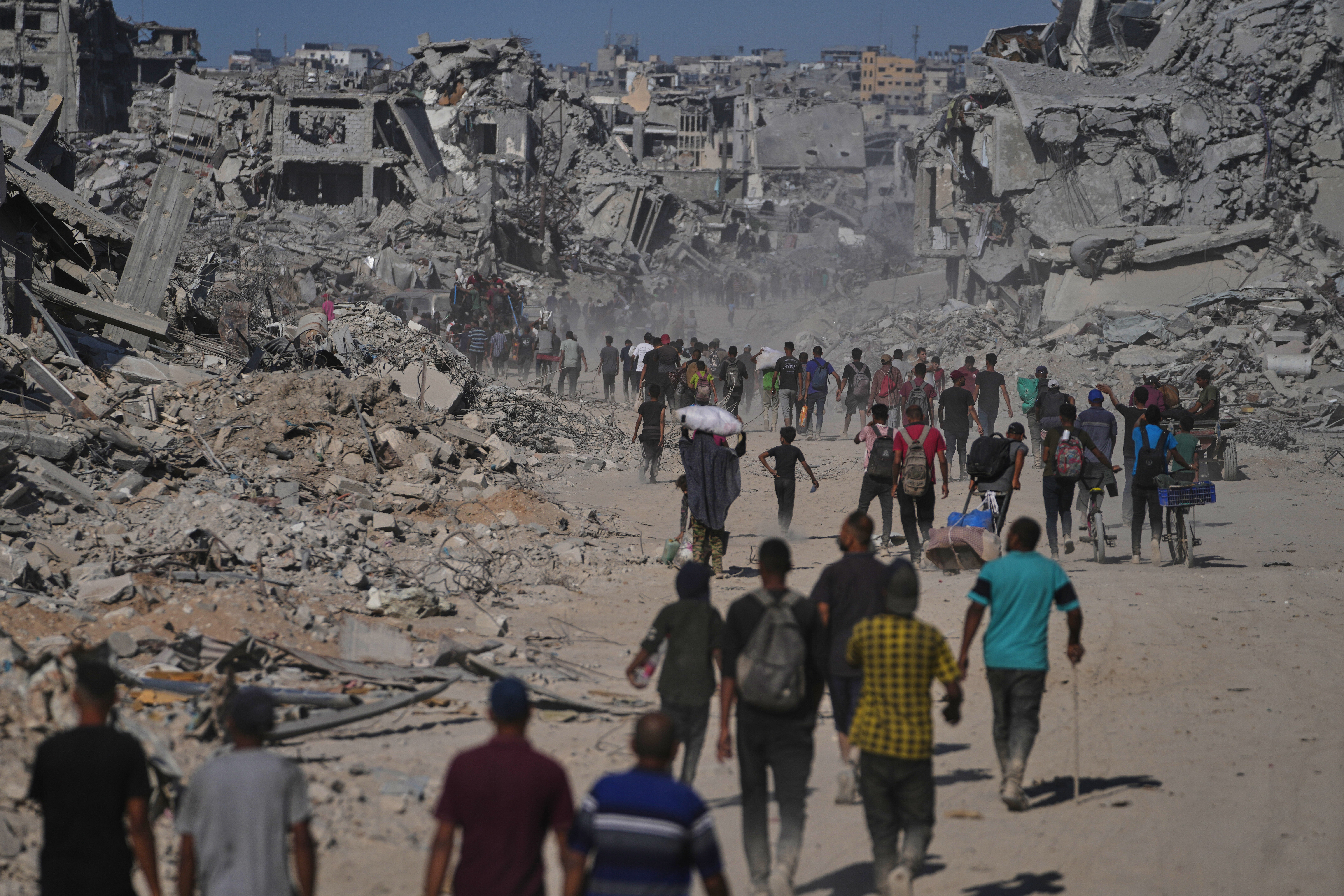 Displaced Palestinians walk past destroyed buildings as they return to their homes in the Zeitoun neighborhood of Gaza City