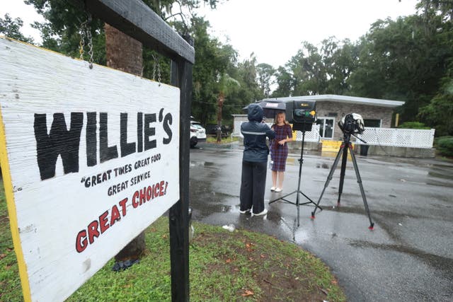 <p>A reporter works outside of Willie's Bar and Grill in St Helena Island, S.C. after a shooting occurred early Sunday, Oct. 12, 2025. (AP Photo/Lewis M. Levine)</p>