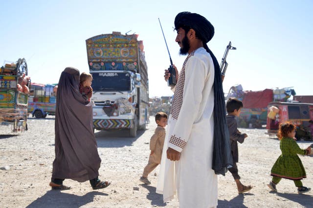 <p>A Taliban security personnel stands guard as Afghans deported from Pakistan arrive at a registration centre at Takhta Pul in Kandahar province</p>