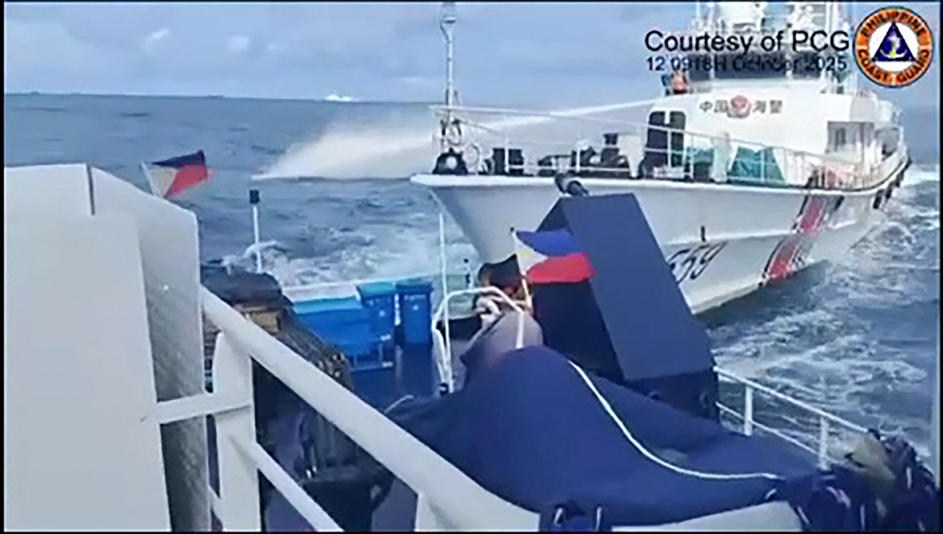 China Coast Guard ship (R) deploying water cannon as seen from a Philippine Bureau of Fisheries vessel during an incident near Thitu island