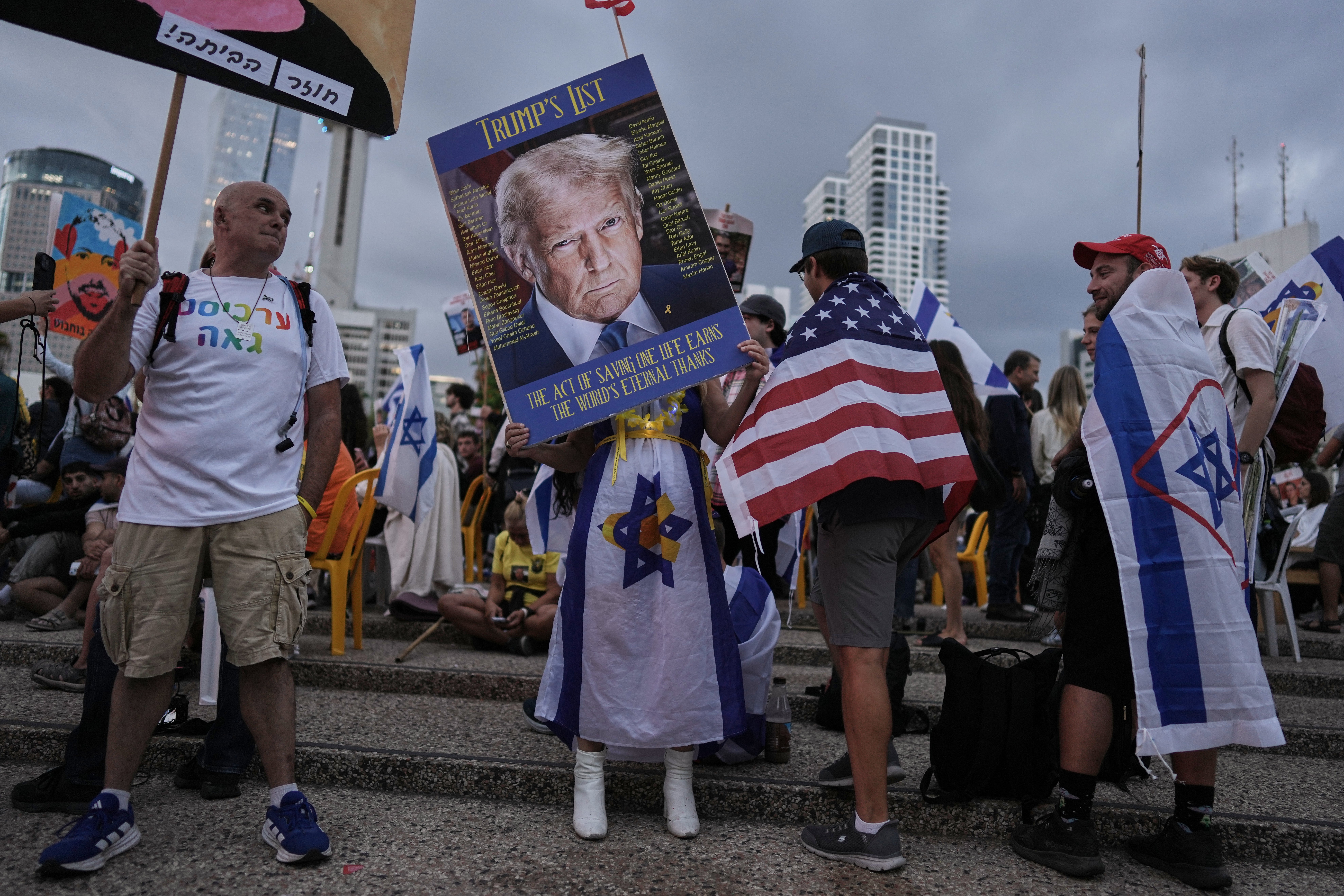 <p>A woman holds an image of Donald Trump in Tel Aviv, Israel</p>