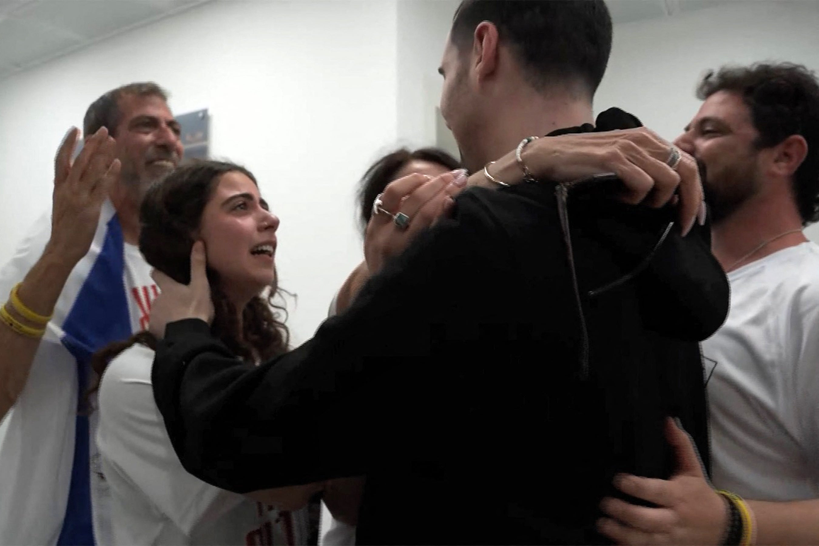 Israeli hostage Guy Gilboa-Dalal (in black) is embraced by his family