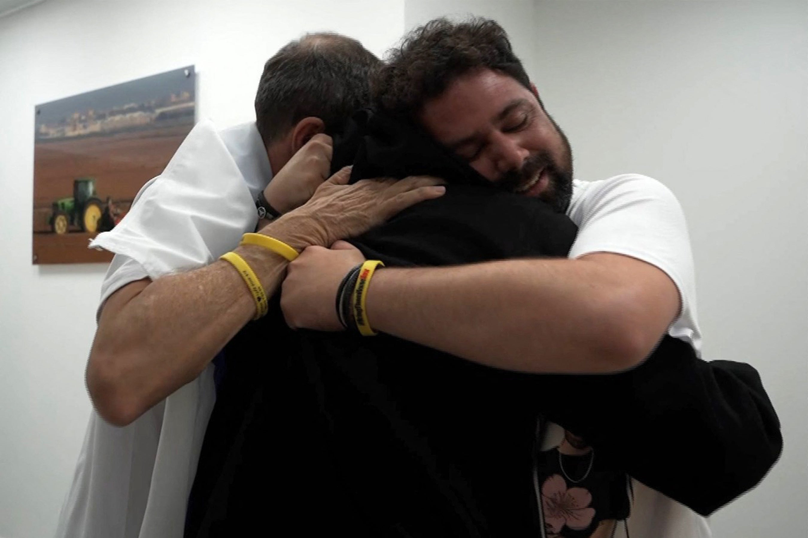 <p>Israeli hostage Guy Gilboa-Dalal (in black) is embraced by his family</p>