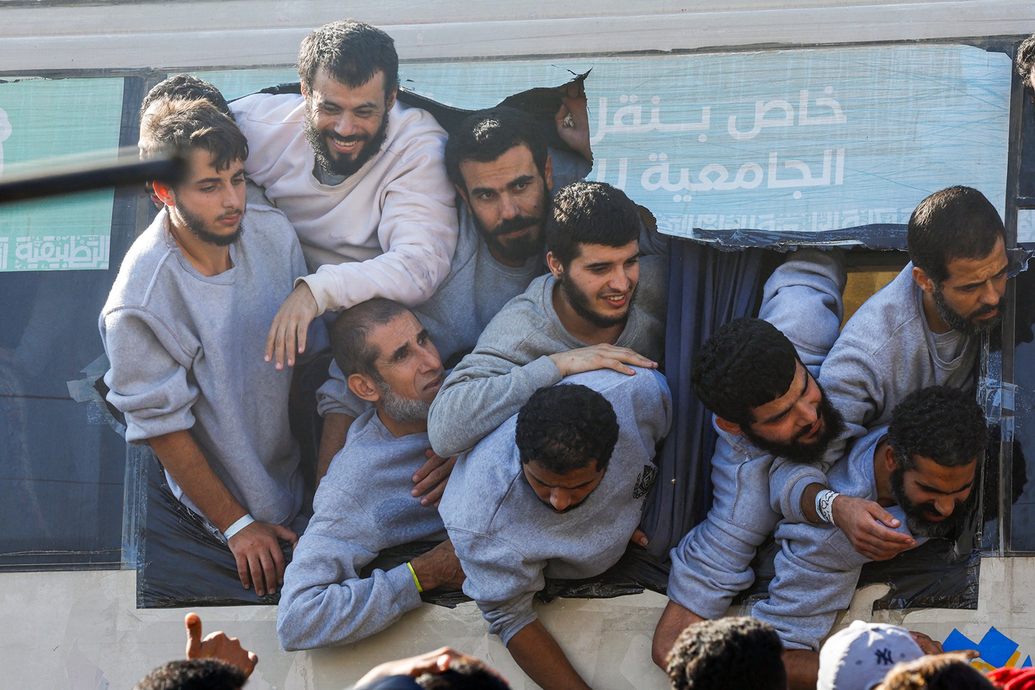 Freed Palestinian prisoners look out of a bus after they were released by Israel