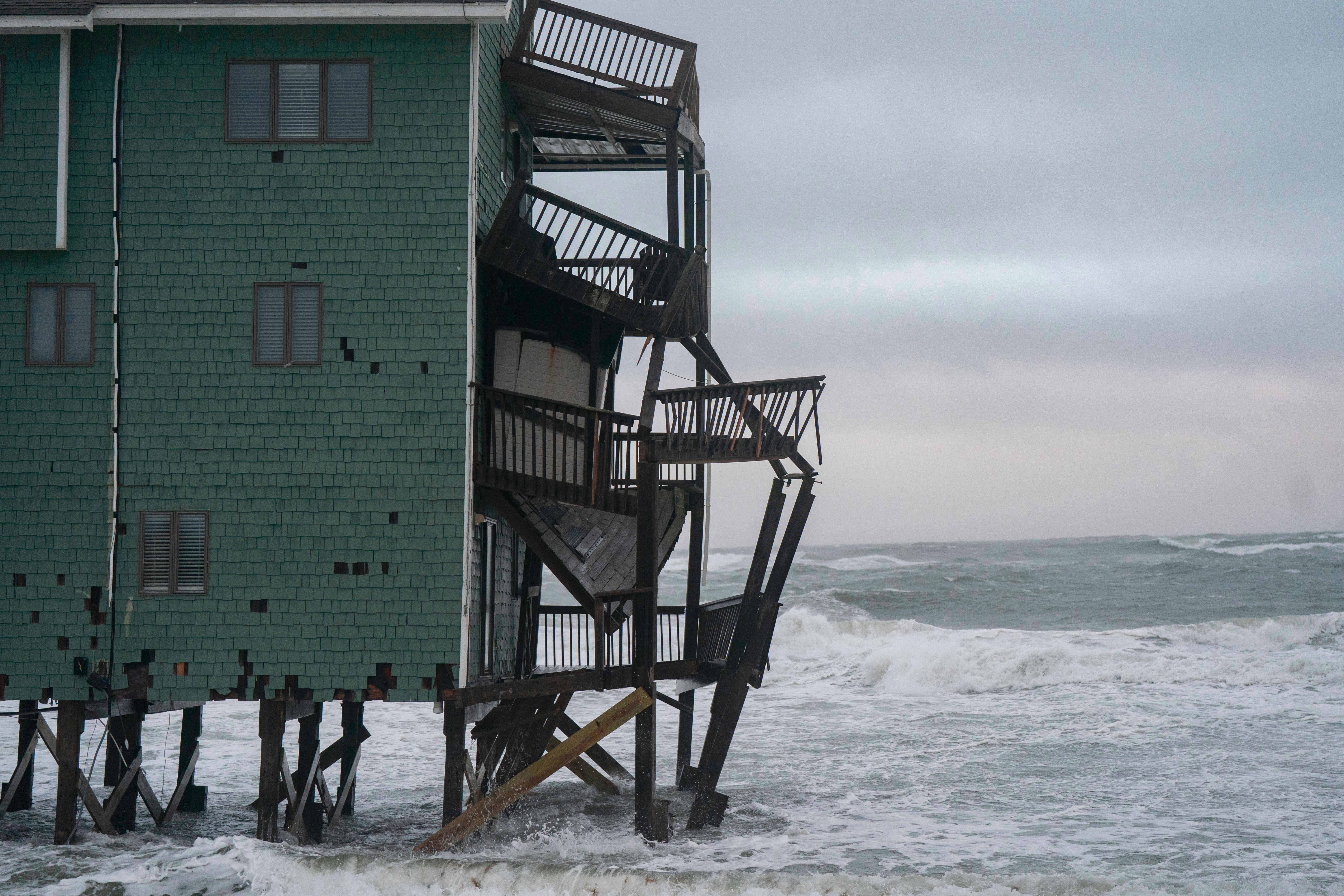 A house on the brink of collapse is seen in the middle of a nor’easter in Buxton, North Carolina while at least eight other beachfront homes collapsed during the storm