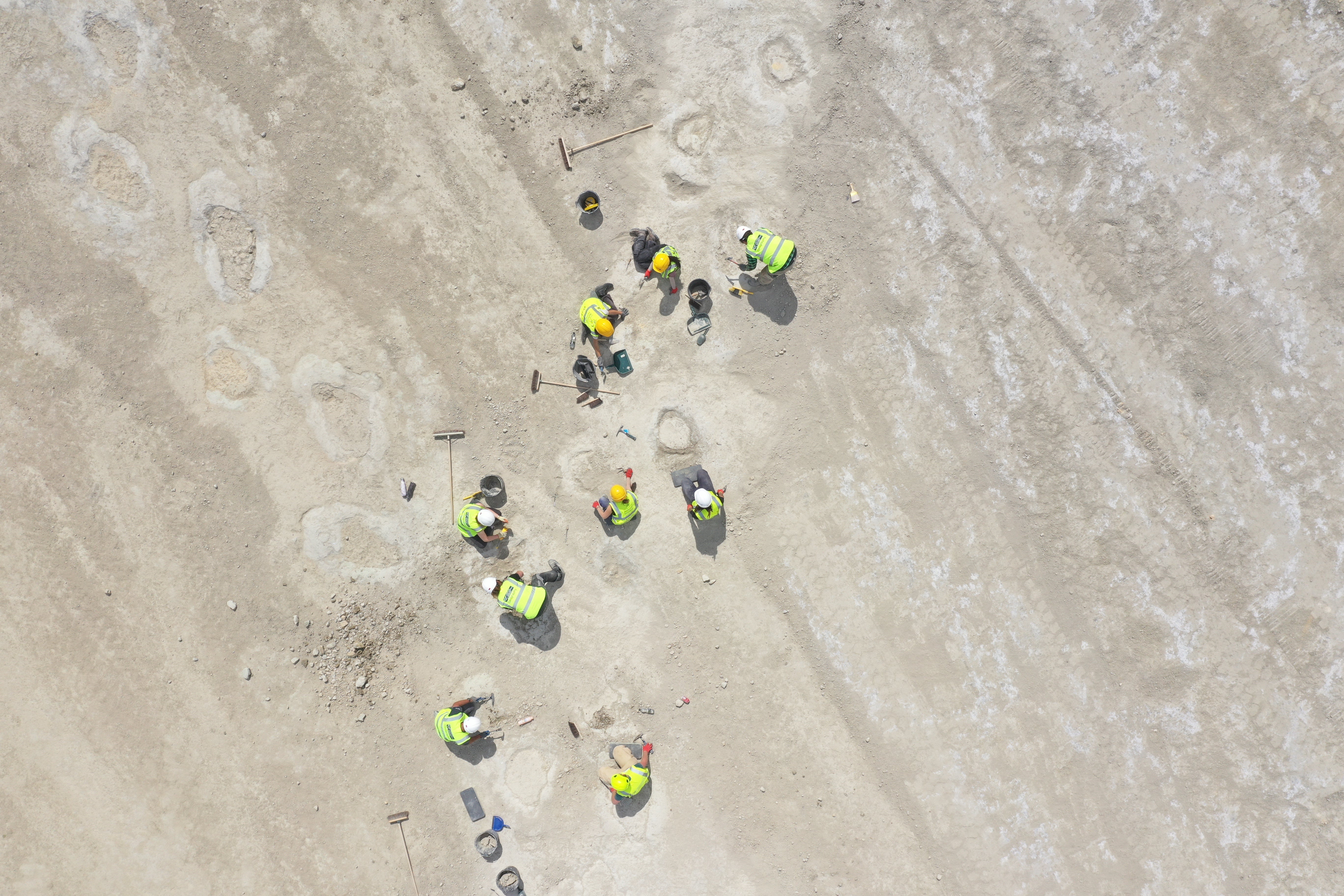 An aerial view of the research team uncovering the footprints