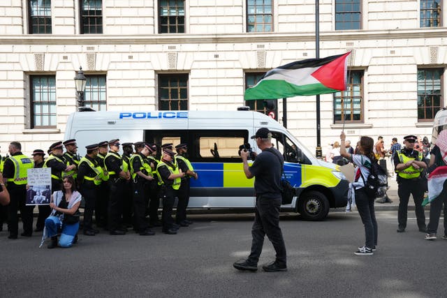 <p>Police officers with demonstrators as people take part in a Palestine Action protest</p>