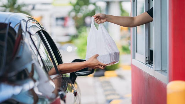 <p>Young Man receiving coffee at drive thru counter</p>