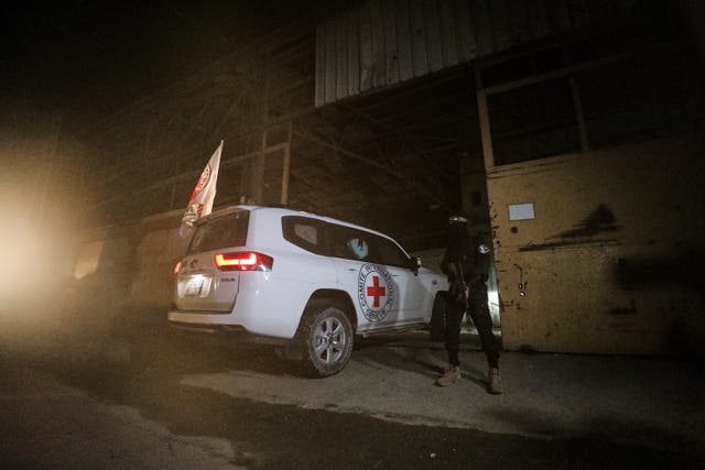 <p>A gunman wearing the uniform of the al-Qassam Brigades, the military wing of Hamas, stands guard as Red Cross vehicles enter a warehouse allegedly to collect coffins containing the bodies of four deceased hostages, in Gaza City, Tuesday, Oct. 14, 2025. (AP Photo/Yousef Al Zanoun)</p>