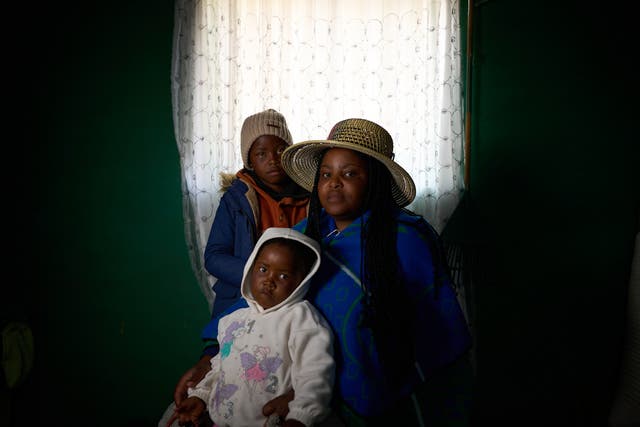 <p>Matseliso Lekhoele, 36, who is HIV-positive, with her two children, Bohlokoa, eight, and Maseabata, four, inside their home in Thaba-Tsoeu, Lesotho. Aid cuts will make medication harder to get</p>