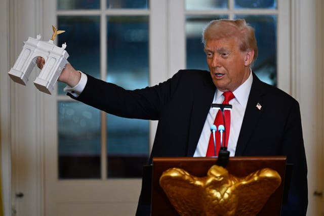 <p>President Trump holds a model of ‘Arc de Trump’ while addressing donors who contributed to build the new ballroom at the White House, Wednesday, Oct. 15, 2025, in Washington</p>