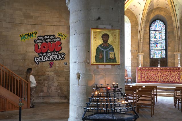<p>A visitor views graffiti artwork from the Hear Us installation in Canterbury Cathedral (Gareth Fuller/PA)</p>