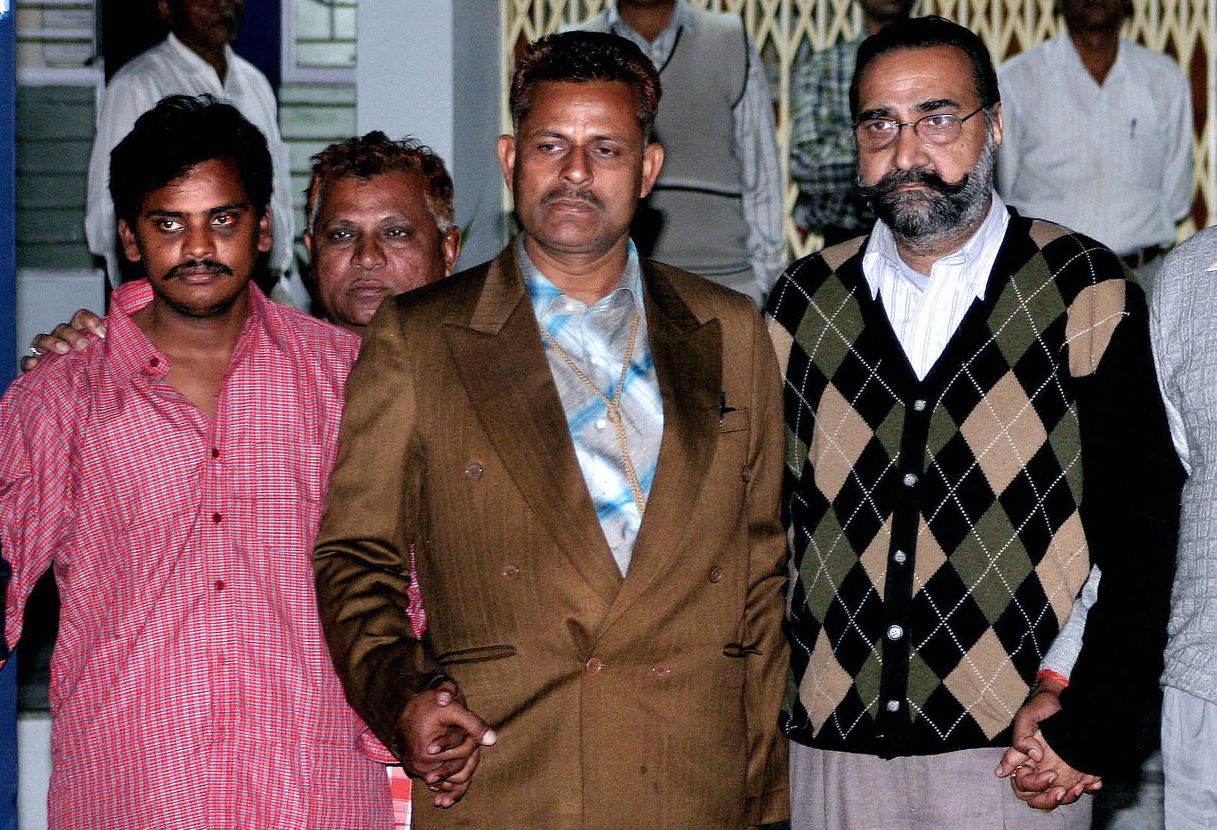 File: Surender Koli (left) and Moninder Singh Pandher (right) are escorted by plainclothes police officers to the Directorate of Forensic Sciences in Gandhinagar, in India's western state of Gujarat, 05 January 2007