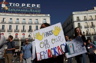 Demonstrators hold signs to protest against U.S. President Donald Trump and his administration during a 'No Kings' rally at Puerta del Sol in Madrid, Spain, October 18, 2025. REUTERS/Violeta Santos Moura