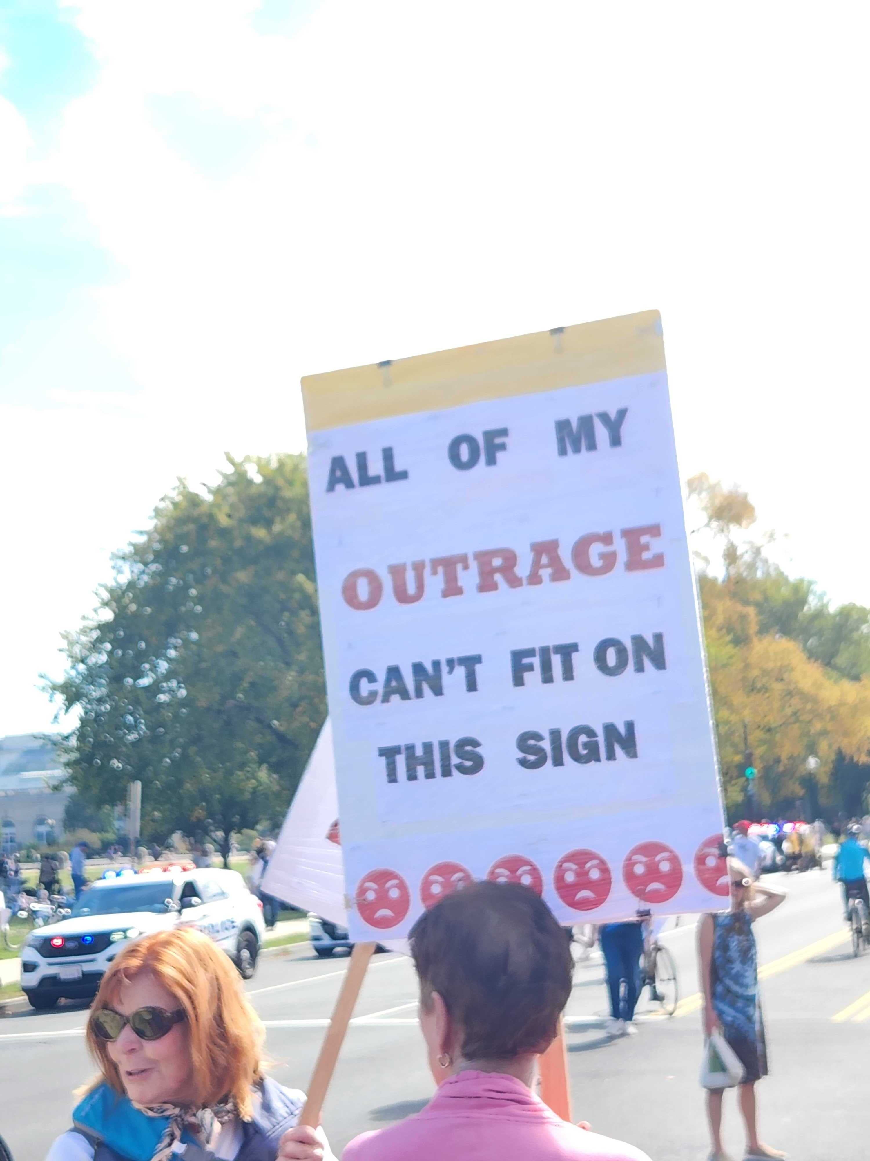 A protester in Washington, DC holds up a sign that reads: ‘All of my outrage can't fit on this sign’