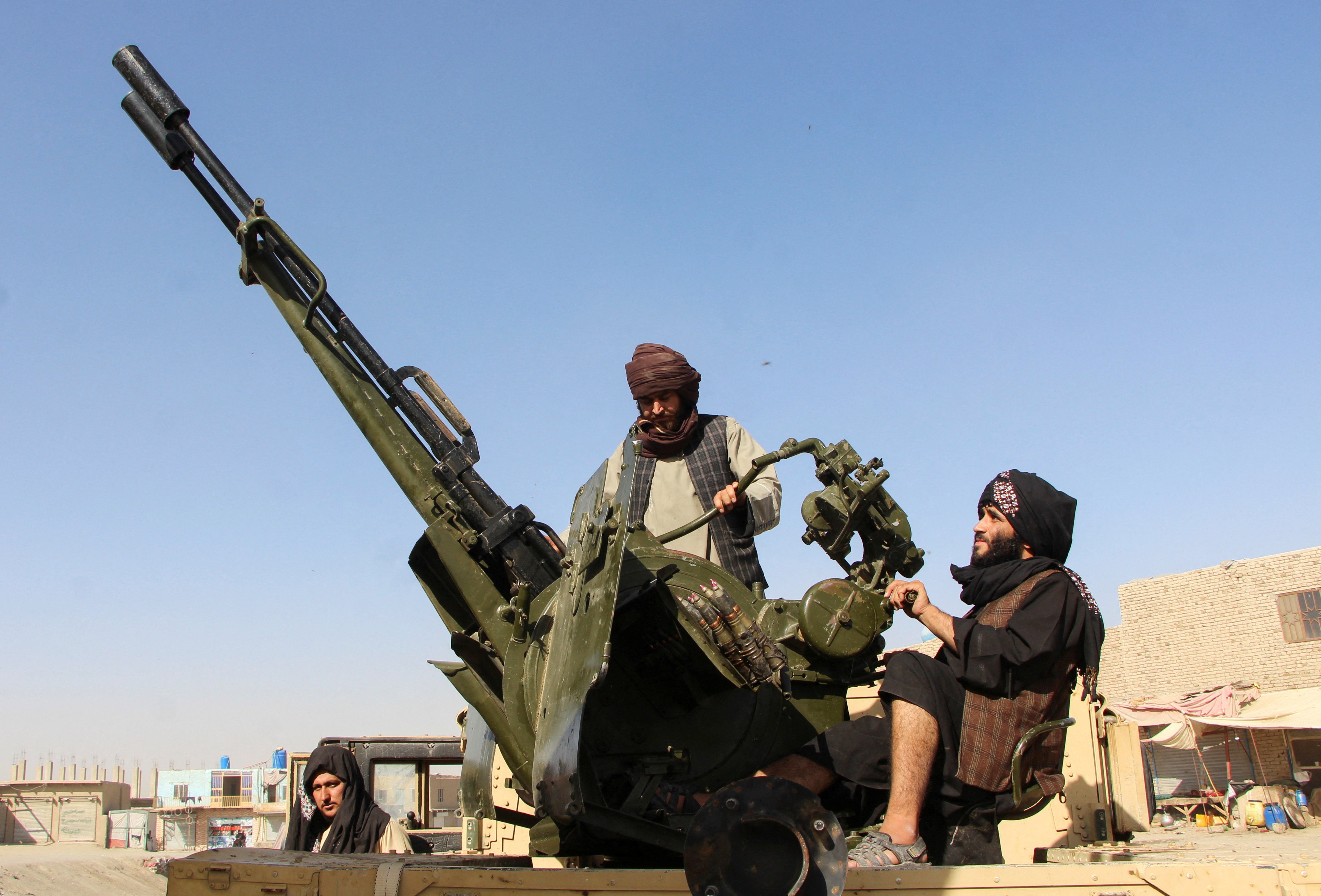 An Afghan Taliban fighter sit next to an anti-aircraft gun near the Afghanistan-Pakistan border in Spin Boldak, Kandahar Province, following exchanges of fire between Pakistani and Afghan forces in Afghanistan