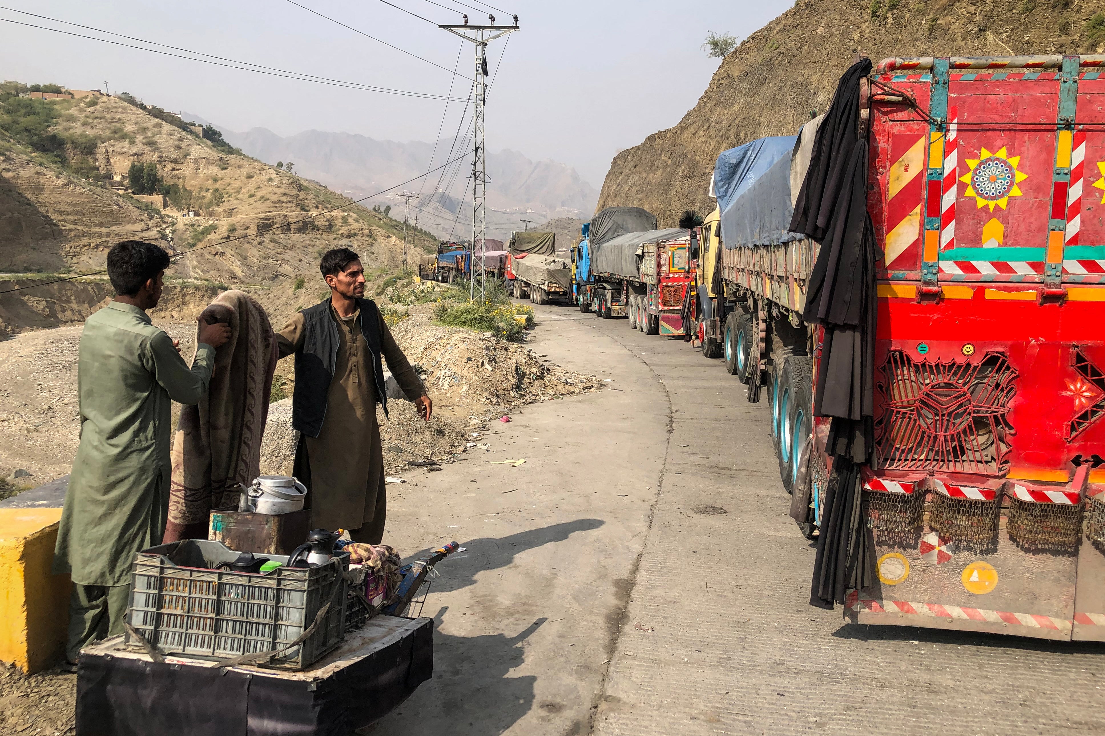 A tea vendor stands near trucks stranded in the town of Torkham by the closing of Pakistan’s border with Afghanistan