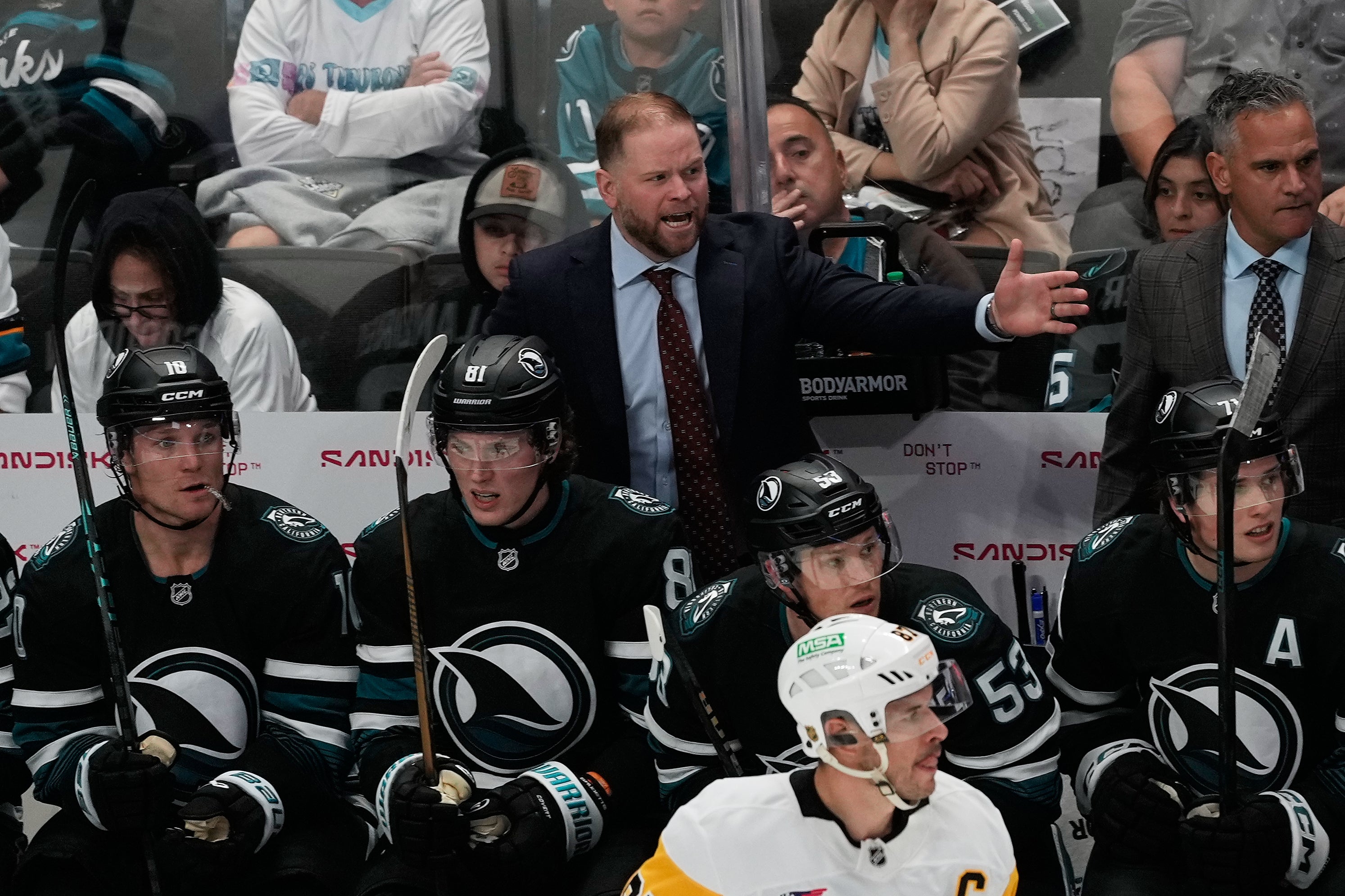 <p>San Jose Sharks head coach Ryan Warsofsky, middle standing, reacts on the bench during the third period of an NHL hockey game against the Pittsburgh Penguins in San Jose, Calif., Saturday, Oct. 18, 2025</p>