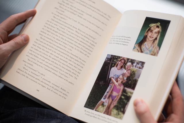 A person reads a copy of Nobody’s Girl by Virginia Roberts Giuffre (James Manning/PA)