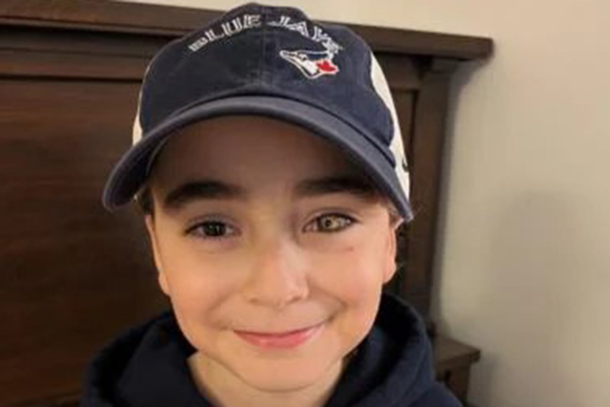 <p>Logan Dorna, 8, has received a special glass eye which is painted gold with red baseball stitch lines to show support for his favourite team</p>