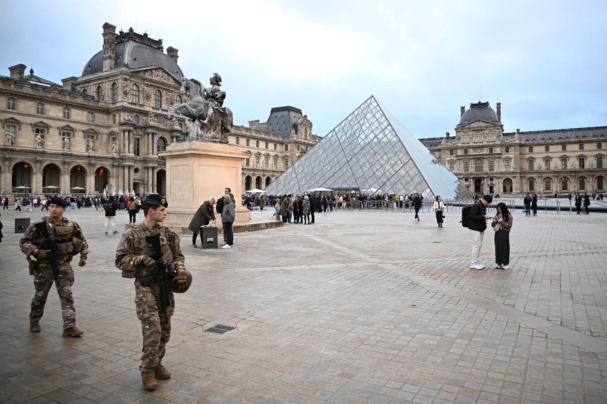 <p>Soldiers patrol as people queue to enter the Louvre museum(AP Photo/Emma Da Silva)</p>