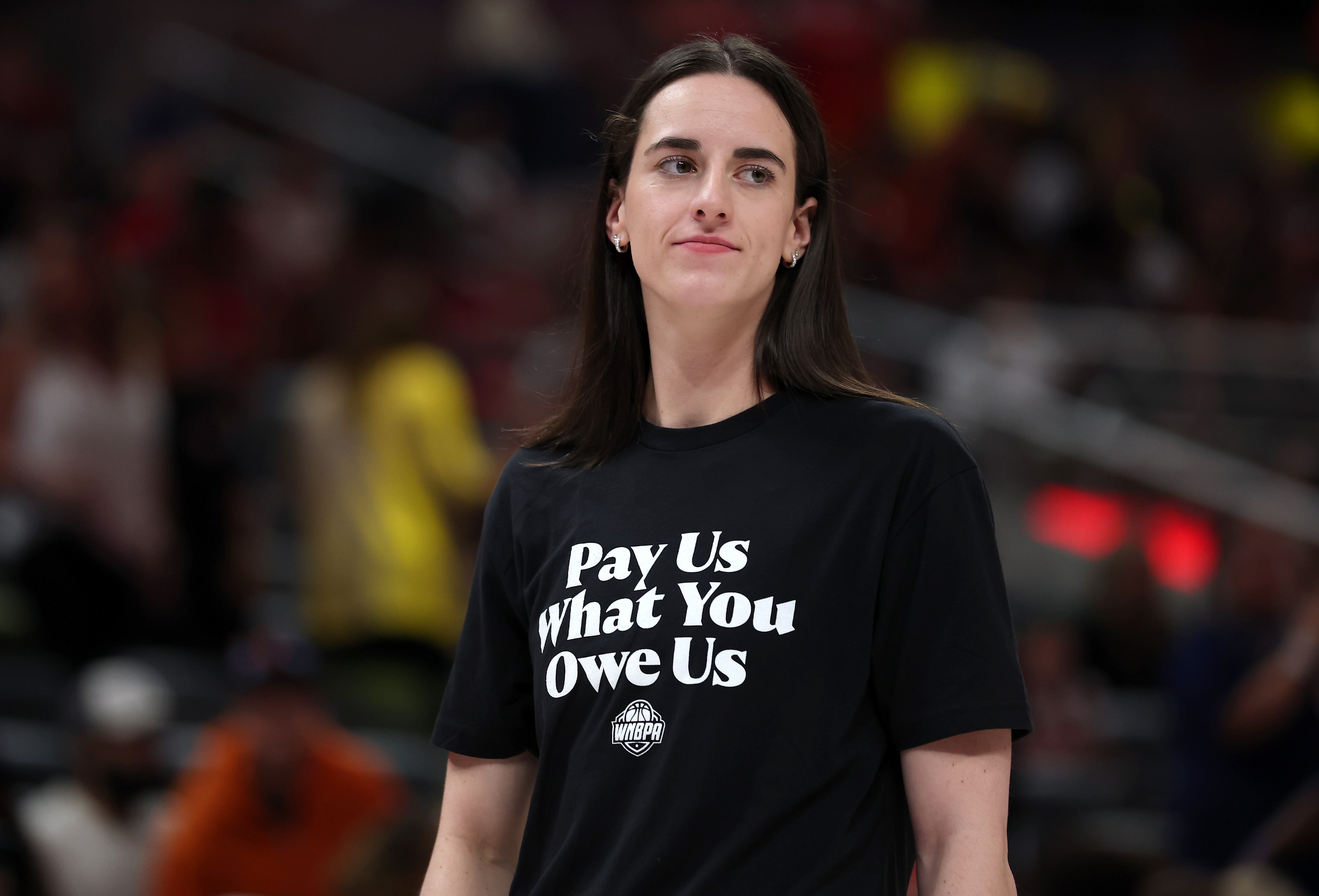 <p>INDIANAPOLIS, INDIANA - JULY 19: Caitlin Clark #22 of the Indiana Fever wears a shirt saying "Pay us what you owe us" prior to the 2025 AT&T WNBA All-Star Game at Gainbridge Fieldhouse on July 19, 2025 in Indianapolis, Indiana. NOTE TO USER: User expressly acknowledges and agrees that, by downloading and or using this photograph, User is consenting to the terms and conditions of the Getty Images License Agreement.  (Photo by Steph Chambers/Getty Images)</p>