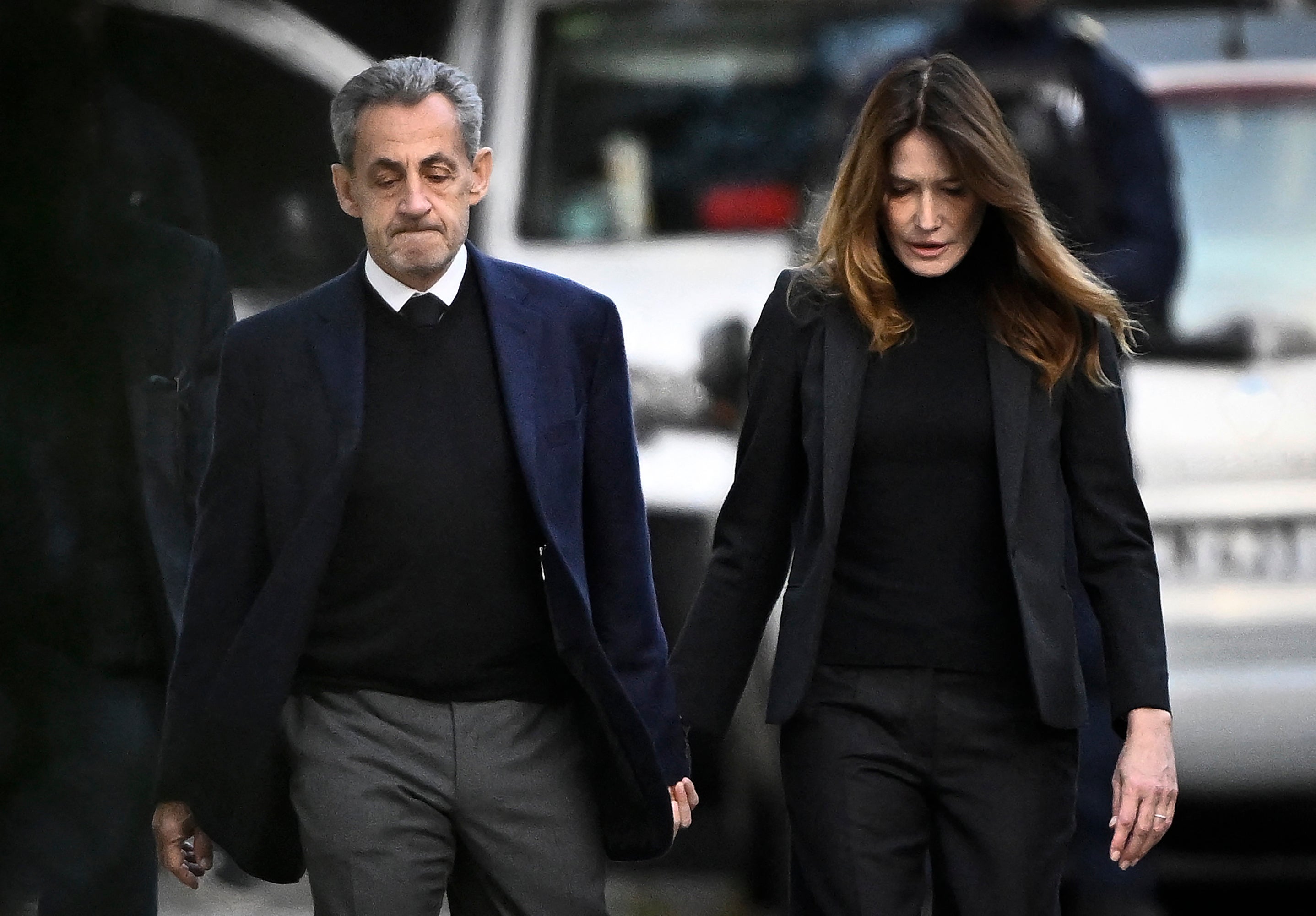 France's former president Nicolas Sarkozy (L), with his wife Carla Bruni-Sarkozy, leaves his residence to present himself to La Sante Prison.