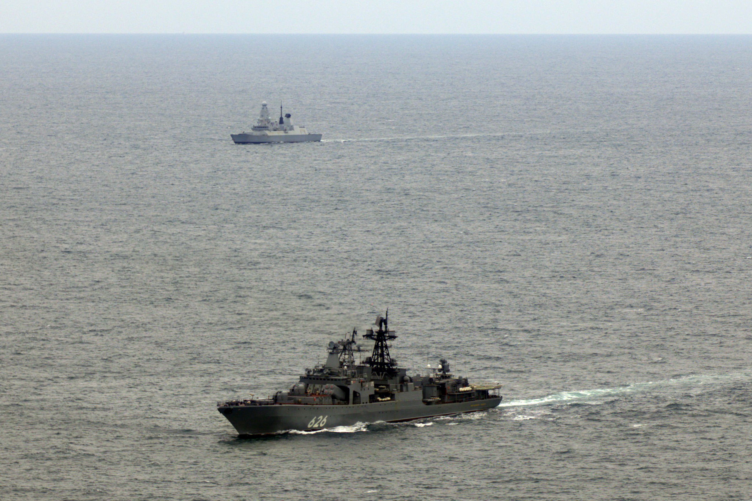 A Type 45 destroyer HMS Duncan (background) shadowing Russian destroyer Vice Admiral Kulakov as it sails through UK waters in the English Channel