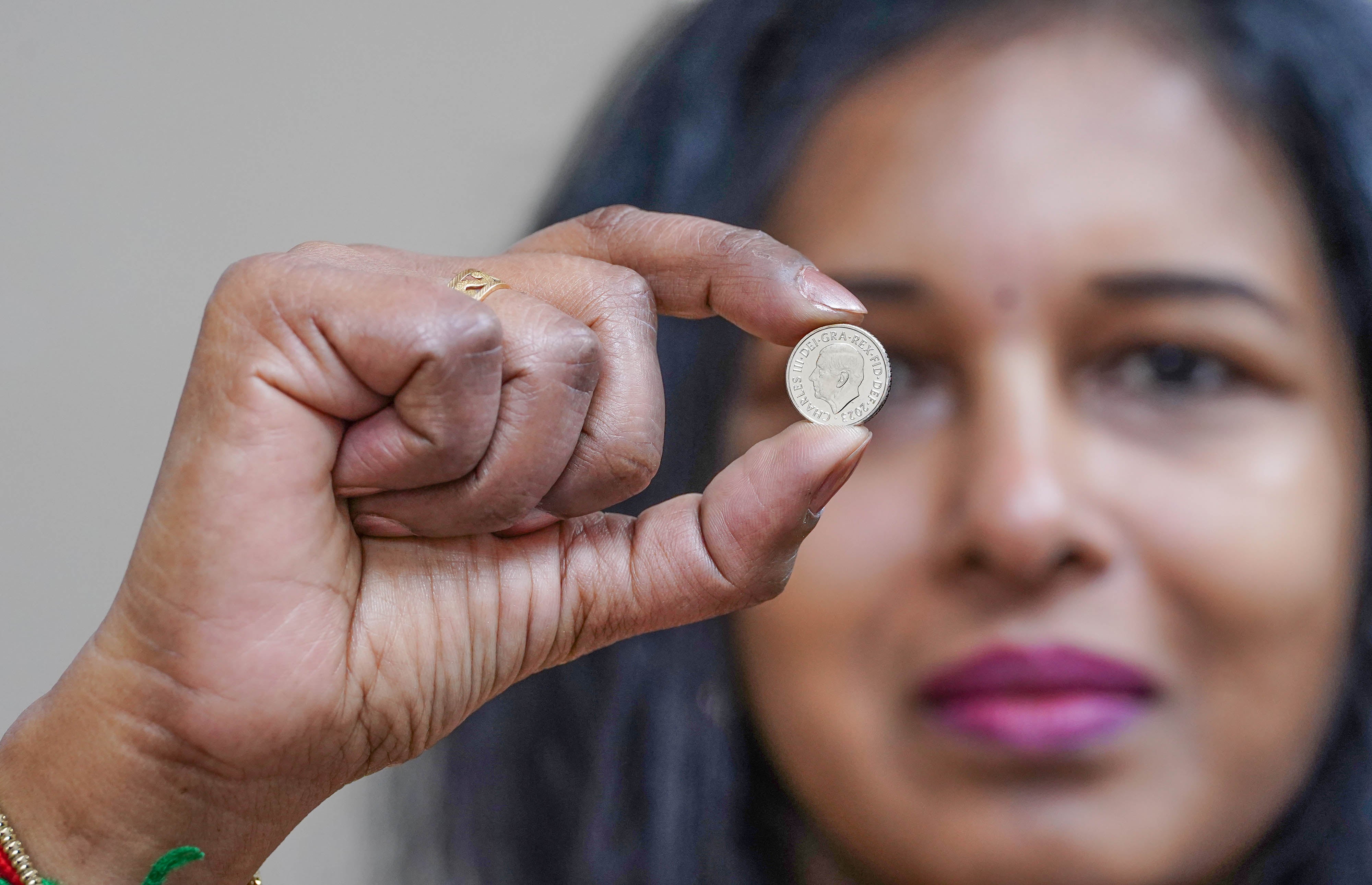 Jubilee Oak Post Office branch manager Vasanthi Balachandar displays the first 5p coins bearing the portrait of King Charles