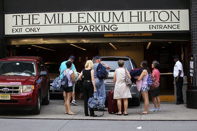 <p>People prepare to check in to the Millenium Hilton hotel in New York City. The hotel giant cut its forecast for 2025 room revenue growth, suggesting that the current weaker demand for vacations within the U.S. will likely persist. </p>