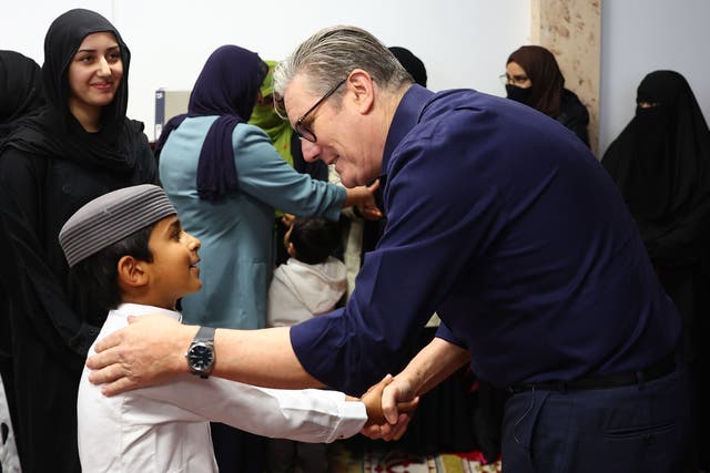 Prime Minister Sir Keir Starmer greeting a young boy during a visit to Peacehaven Mosque in East Sussex (Pete Nicholls/PA)