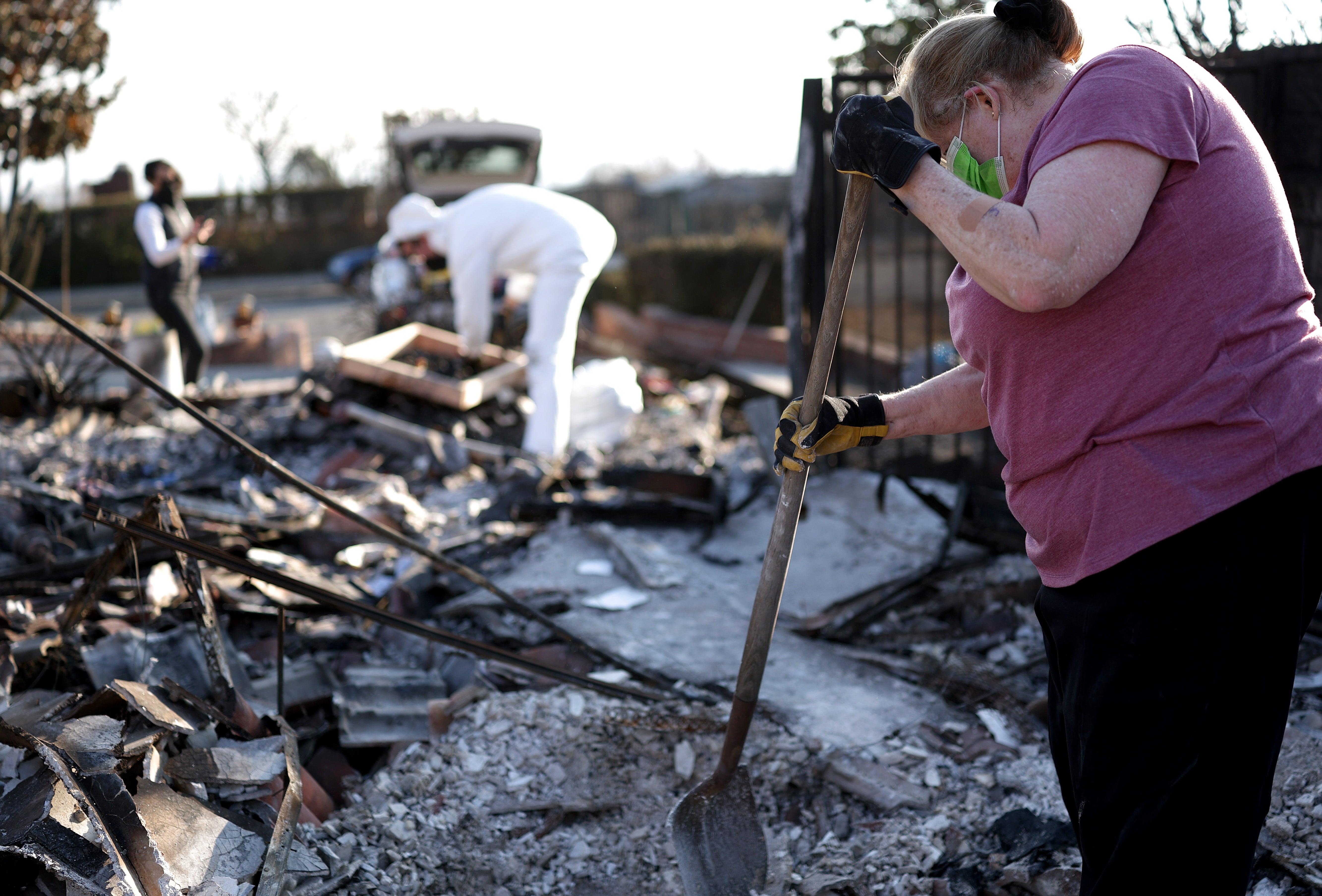 Uma mulher e sua sobrinha vasculham os restos de sua casa após o incêndio na Eaton em janeiro em Pasadena, Califórnia. O incêndio foi o incêndio florestal mais caro já registrado, causando mais de US$ 60 bilhões em danos