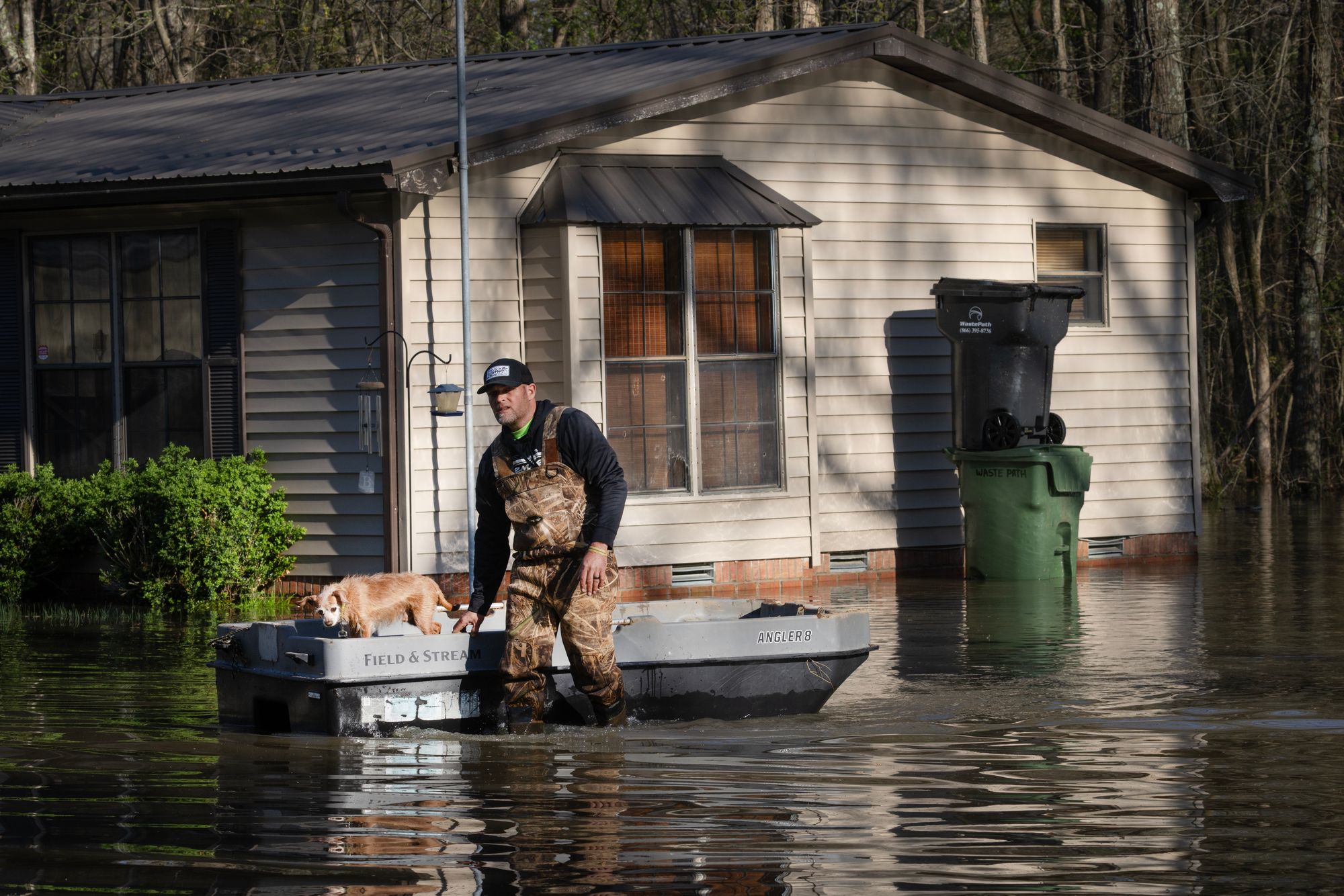 Um homem caminha com seu cachorro nas enchentes do lado de fora de sua casa em Paducah, Kentucky, em abril passado. Tempestades severas causam grandes inundações nos estados e na região central dos Estados Unidos no inverno e na primavera