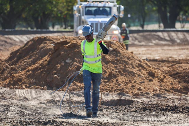 <p>A worker walks through a mound of dirt dumped at the East Potomac Golf Course in Washington, D.C.</p>