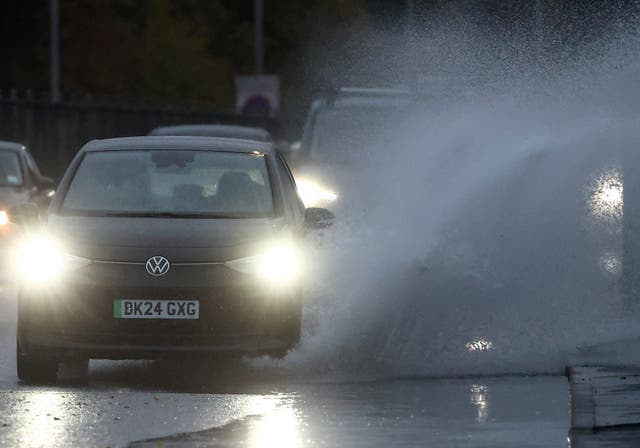 <p>A car drives through surface water as Storm Benjamin arrives in parts of the UK</p>