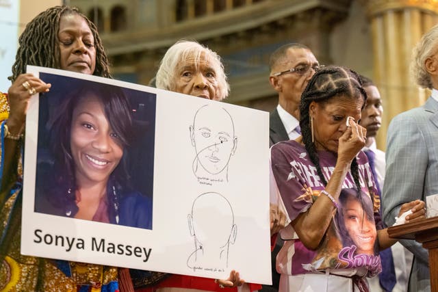 <p>Sonya Massey's family members hold a poster with her photo and a diagram from her autopsy report. Massey was killed in her home on July 6, 2024, by a Sangamon County Sheriff's deputy </p>