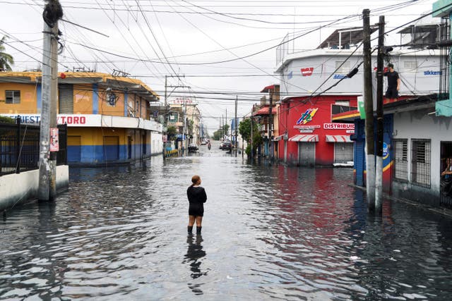 <p>A woman is standing on a street flooded by rains caused by Tropical Storm Melissa, in Santo Domingo, Dominican Republic</p>