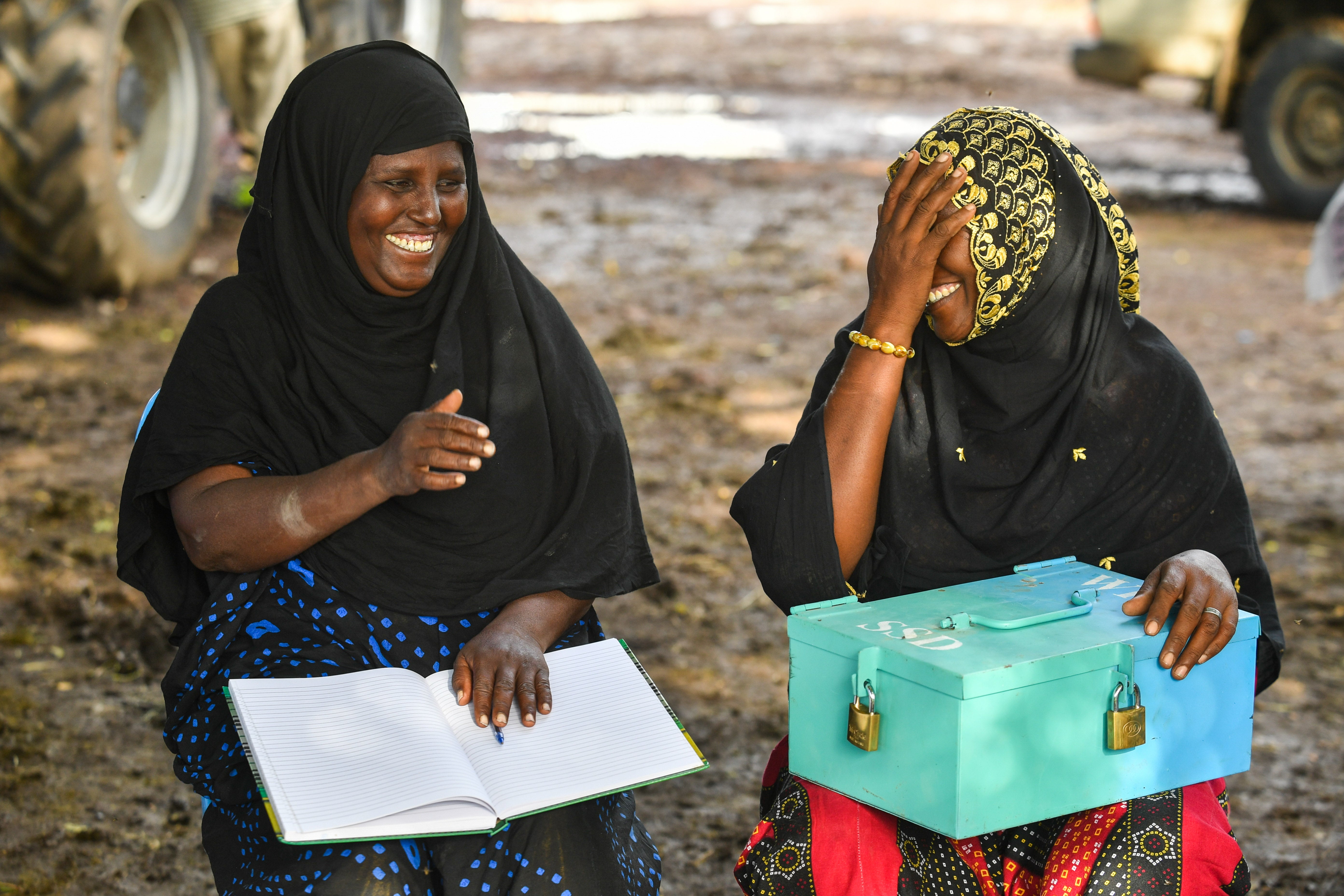 Kemice Ali (left) and Malika Mehamed (right) are seen holding a savings box belonging to their village saving and loan association (VSLA), which acts as a substitute for a formal bank for rural communities. Said is part of the same VSLA group