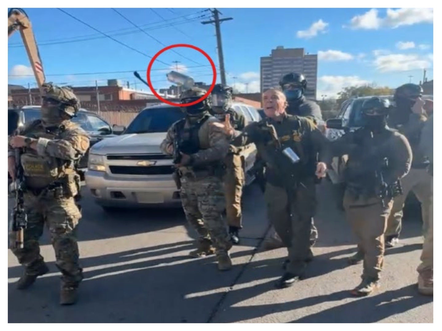 An image in court filings appears to show Border Patrol chief Gregory Bovino lobbing a tear gas canister at protesters in Chicago October 23