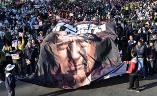 Anti-Trump activists hold a giant banner depicting the U.S. president