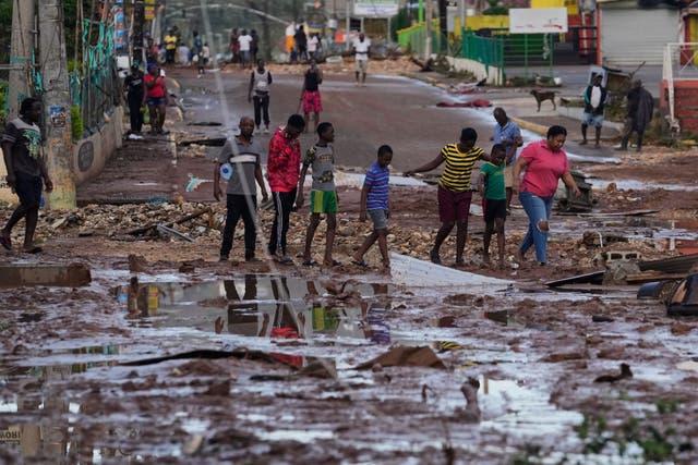 People walk through Santa Cruz, Jamaica (Matias Delacroix/AP)