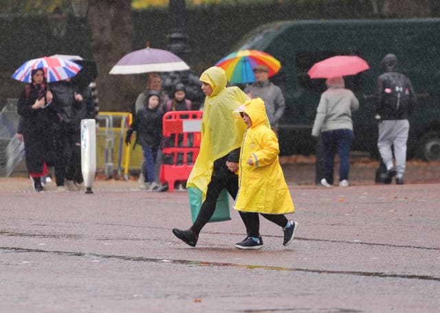 <p>People walking in the rain on The Mall in London</p>